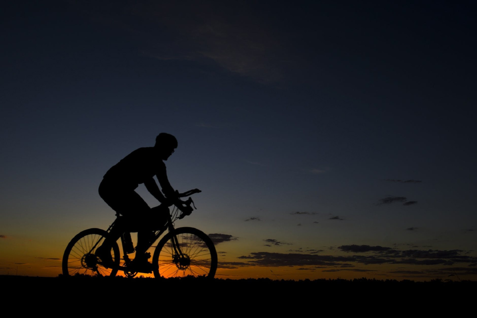 siloutte of person on a bike in the sunset